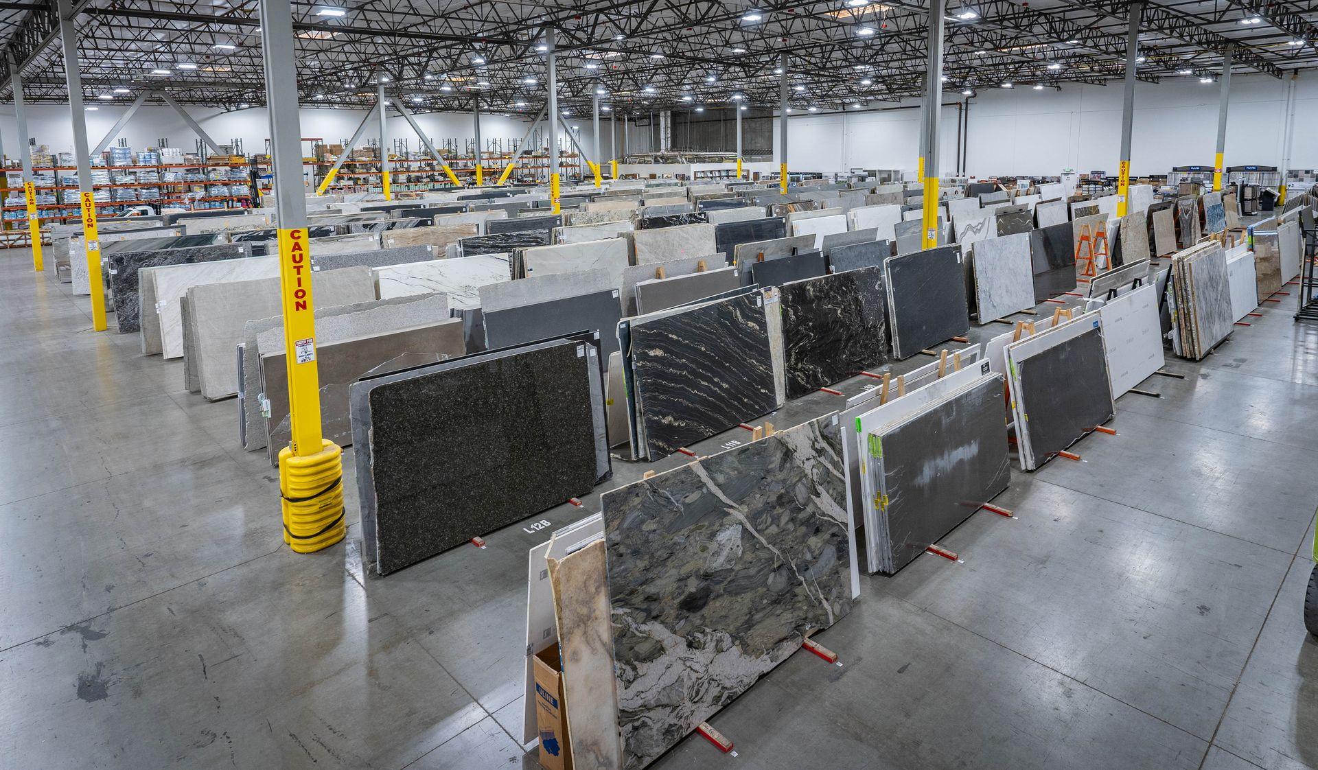 Rows of granite quartz and natural stone countertop slabs at Nova Tile Reno warehouse