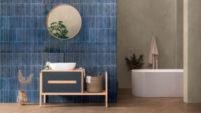 Bathroom accent wall with vertical blue large format subway tiles.