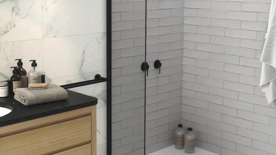 A modern bathroom shower featuring light gray Nantes 3x12 Matte Ceramic Subway Tile on the walls