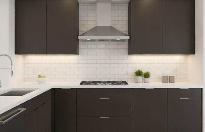 White subway tile backsplash with white grout installed in modern kitchen setting with black cabinet
