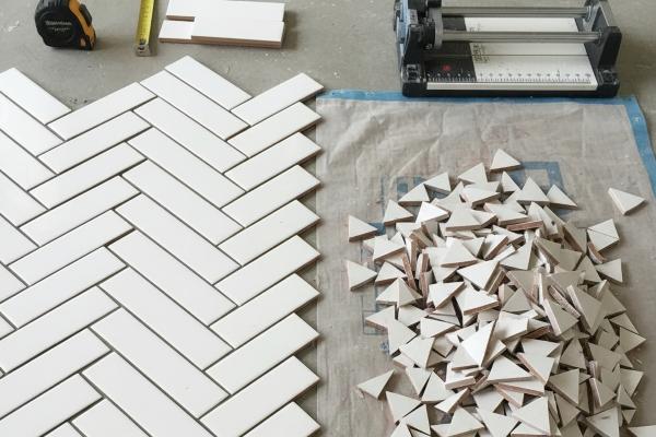 Herringbone pattern subway tile layout with 45-degree angle cuts showing increased waste material