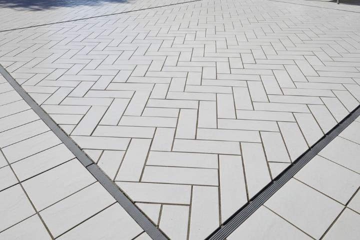 Modern herringbone subway tile pattern installation with proper expansion joints preventing future cracks