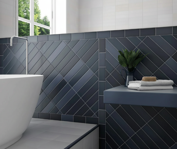 Close-up of a decorative tile feature wall in a bathroom, using dark blue tiles laid in a striking diagonal pattern and framed to create panels.