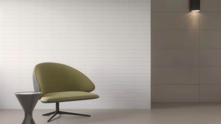 Modern living room with a matte porcelain subway tile wall, an olive green armchair, and a dark side table.