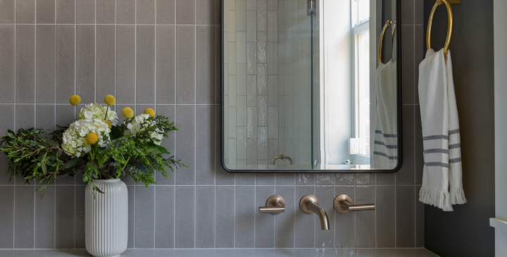 Gray subway tile bathroom with brass faucet