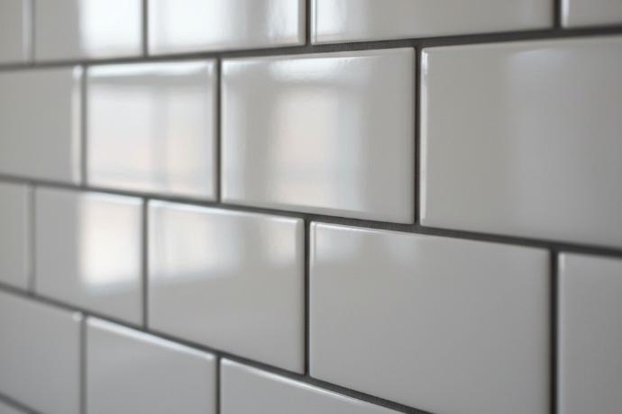 Close-up of 3x9 ceramic subway tile showing reflective glossy finish