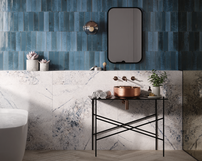 Modern bathroom featuring Aveline glossy zellige look porcelain subway tile in blue, paired with marble-look tile and a copper vessel sink.