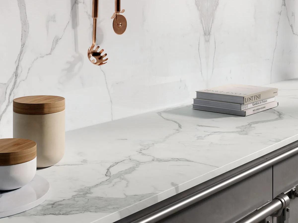 Statuario Principe porcelain slabs countertop styled with wooden jars and books