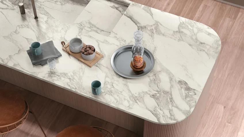 Close-up of Calacatta Magnifico porcelain slabs countertop with decorative accessories and natural veining.