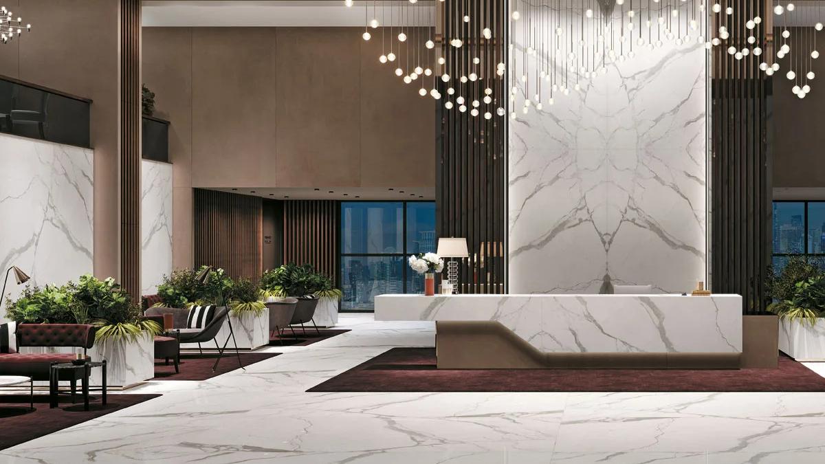 Luxury lobby featuring Classic Statuario porcelain slabs on feature wall with cascading pendant lights.