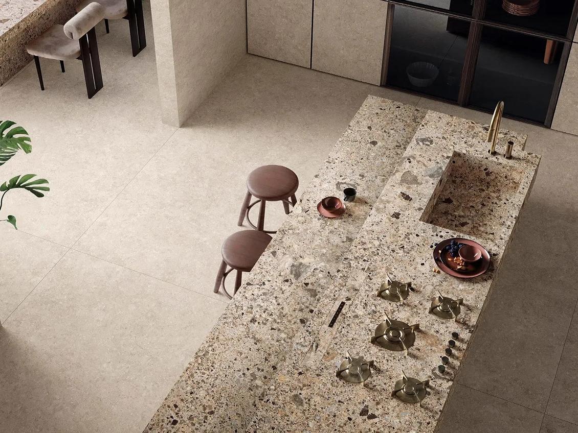 Ceppo Romano porcelain slabs on large kitchen island with built in cooktop and bar seating.