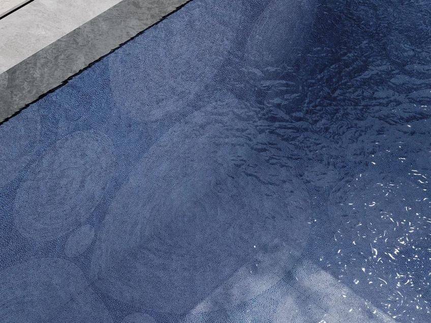 Pool water reflecting Holos Aegean Blue Porcelain Slabs with circular mosaic underwater design.