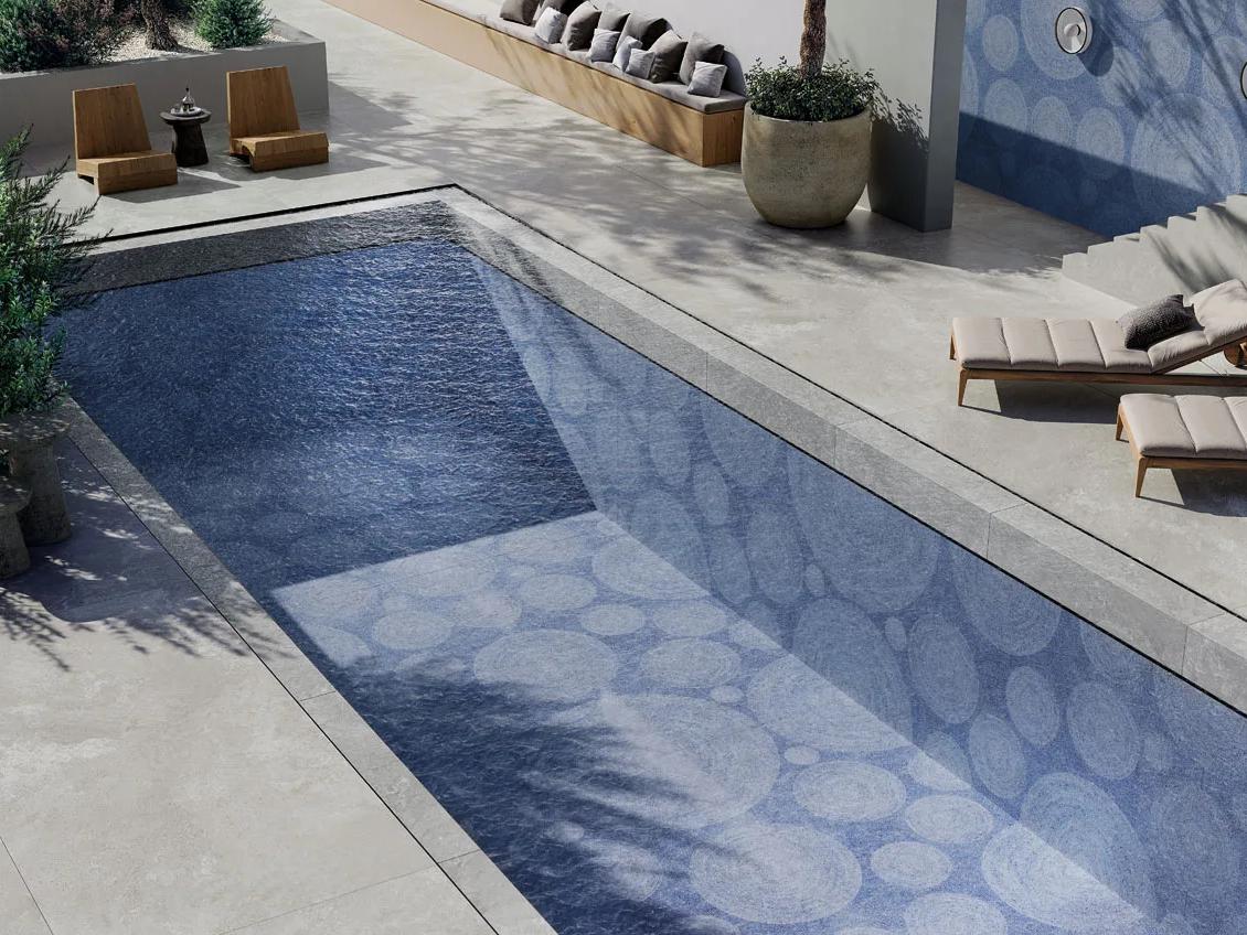 Resort-style pool with Holos Aegean Blue Porcelain Slabs creating elegant blue mosaic water feature.