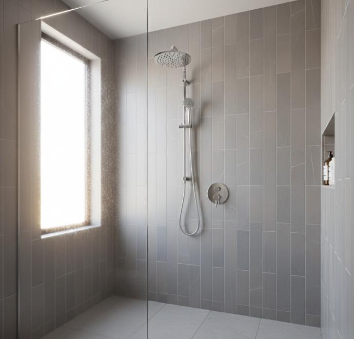 Vertical grey porcelain tile layout on shower wall with chrome fixtures and rainfall showerhead.
