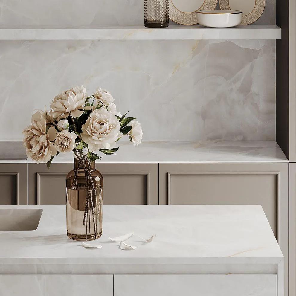Contemporary kitchen featuring Onyx White porcelain slabs as backsplash with white cabinetry.