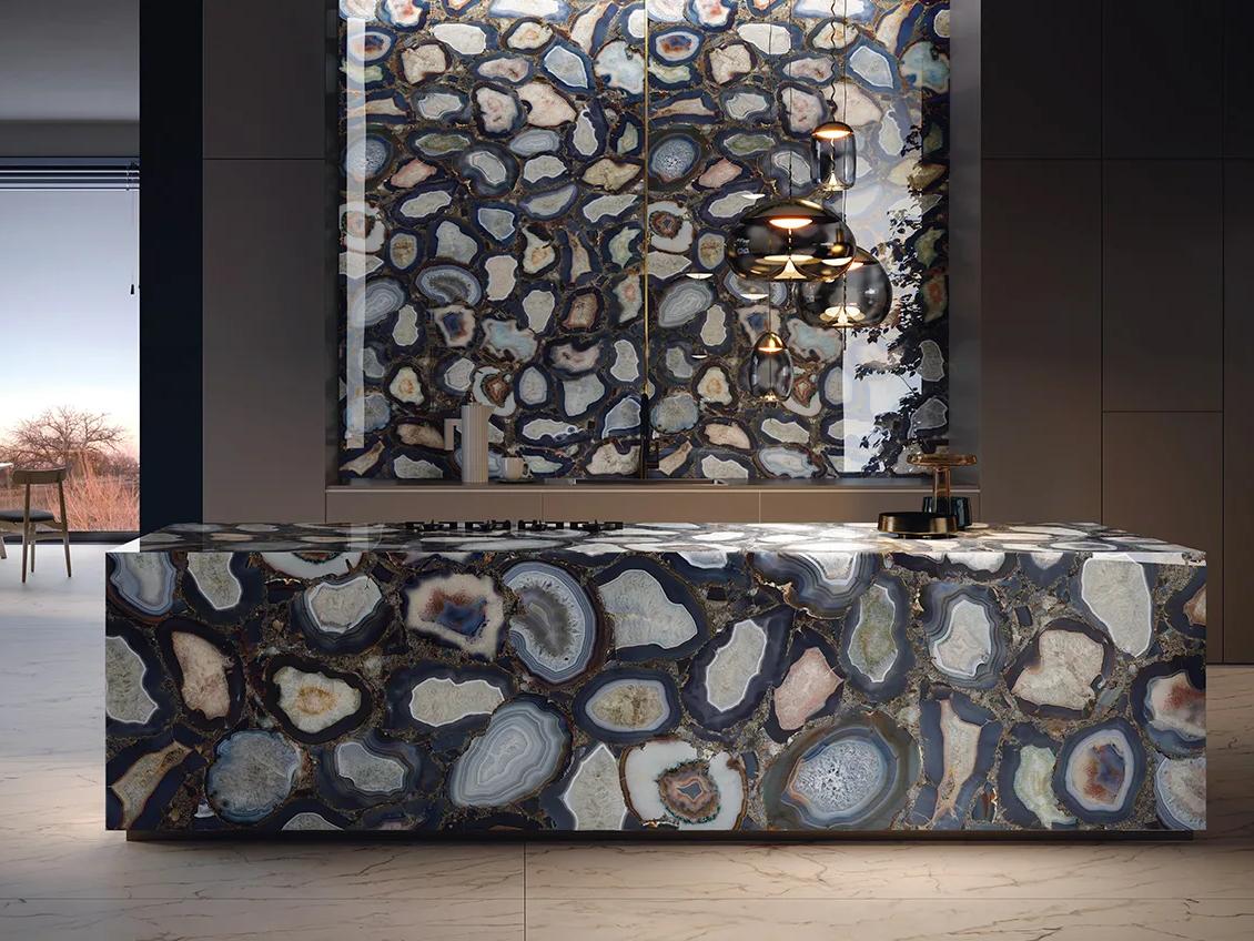 Bold kitchen island and wall panels fully clad in agate-patterned Cammeo porcelain slabs.