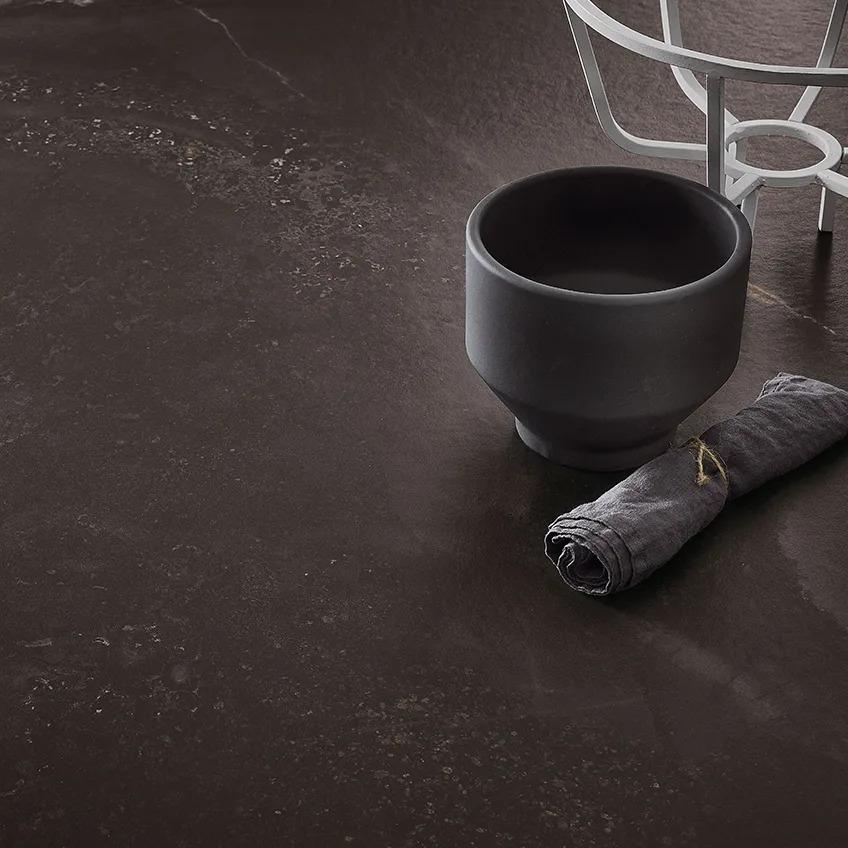 Andromeda porcelain slabs with matte finish showing rolled towel and decorative bowl.