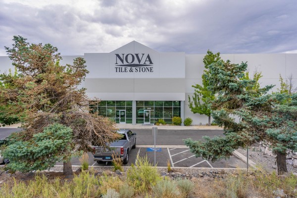 Nova Tile and Stone company showroom exterior with large windows and parking lot.