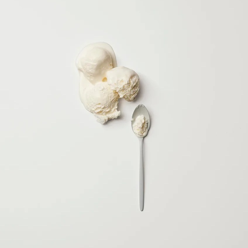 Vanilla ice cream scoop on spoon showcasing the pure white tone of Absolute White porcelain slabs.