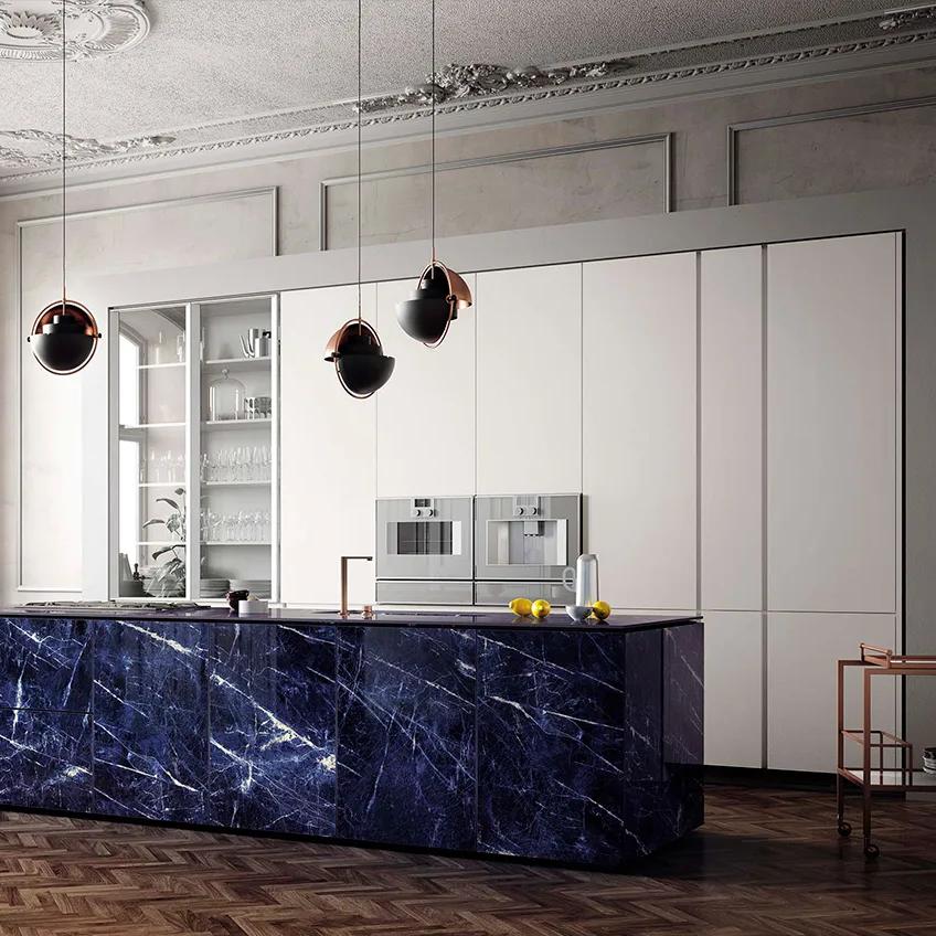 Elegant kitchen design pairing dark blue stone island with Absolute White porcelain slabs.