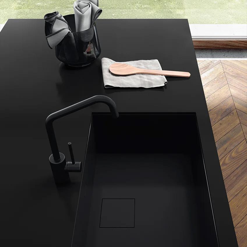 Absolute Black porcelain slabs kitchen countertop with integrated sink and modern black faucet.