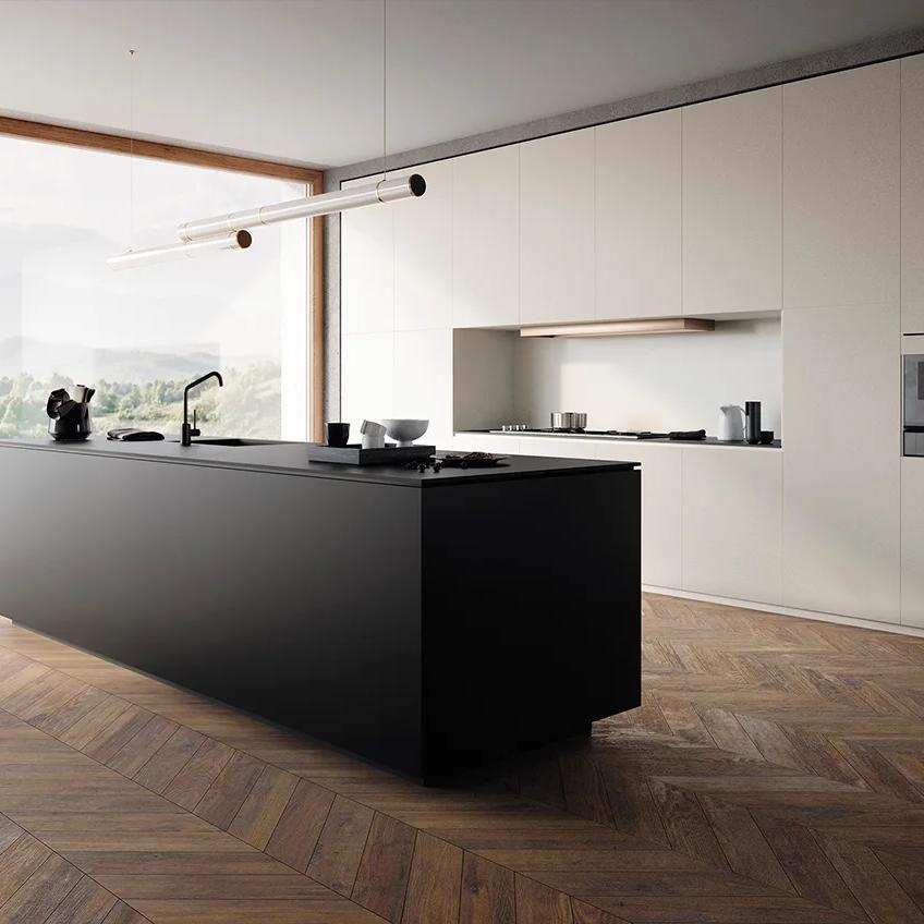 Absolute Black porcelain slabs kitchen island in modern open space with herringbone wood flooring.