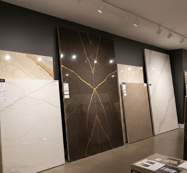 Showroom display of large artificial stone slabs in various marble and metallic patterns