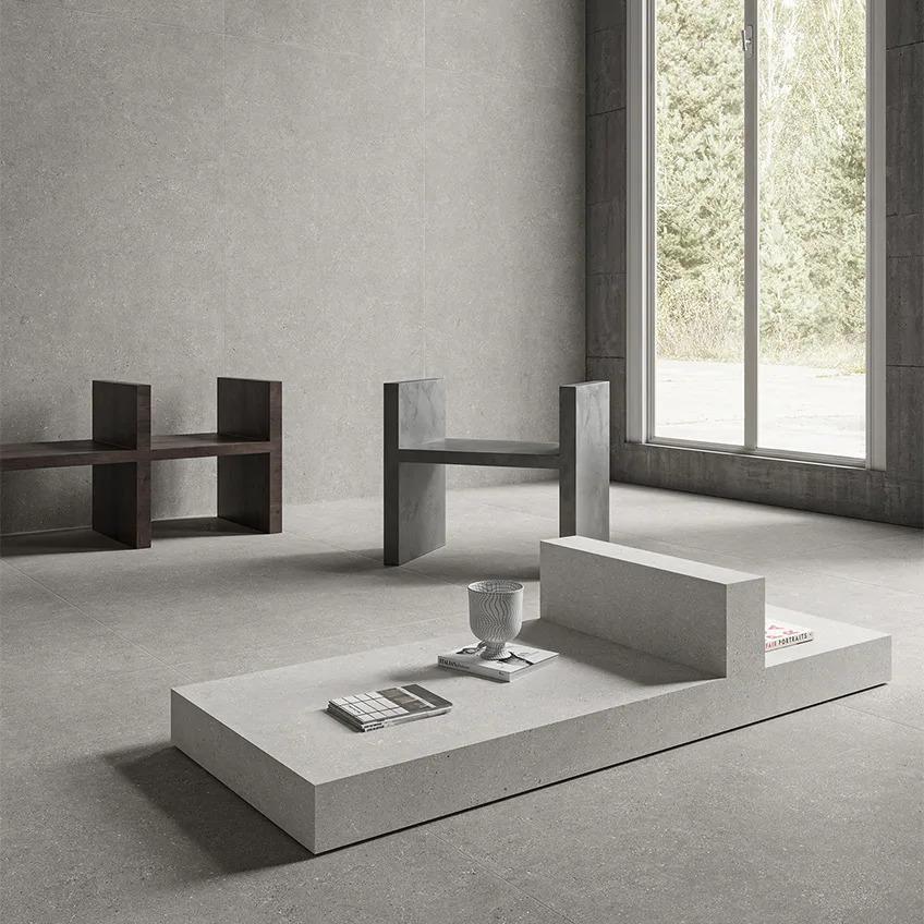 Sandstone Silver porcelain slabs creating seamless surfaces in minimalist room with large windows and decor.