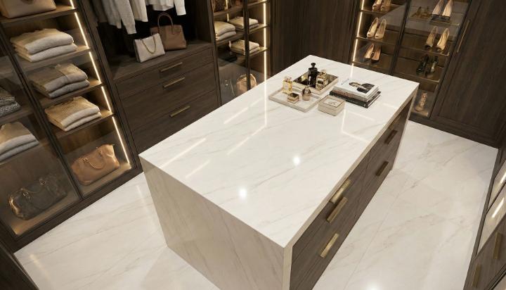 Minimalist walk-in closet featuring a white porcelain slab island