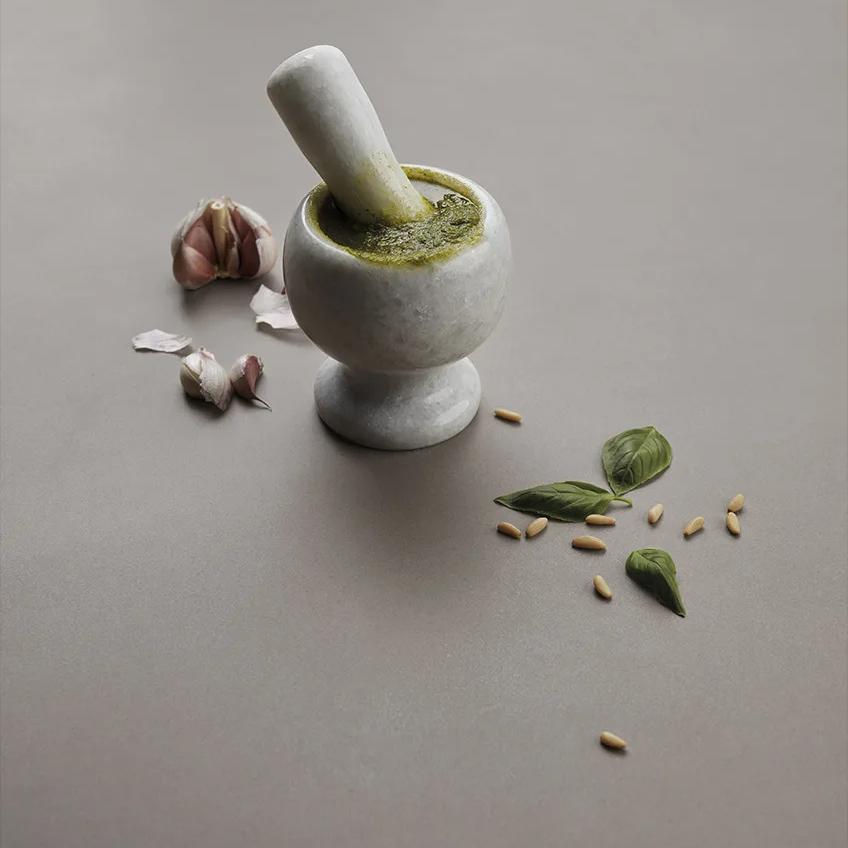 Bercy porcelain slabs in kitchen with mortar and pestle displaying natural grey surface.