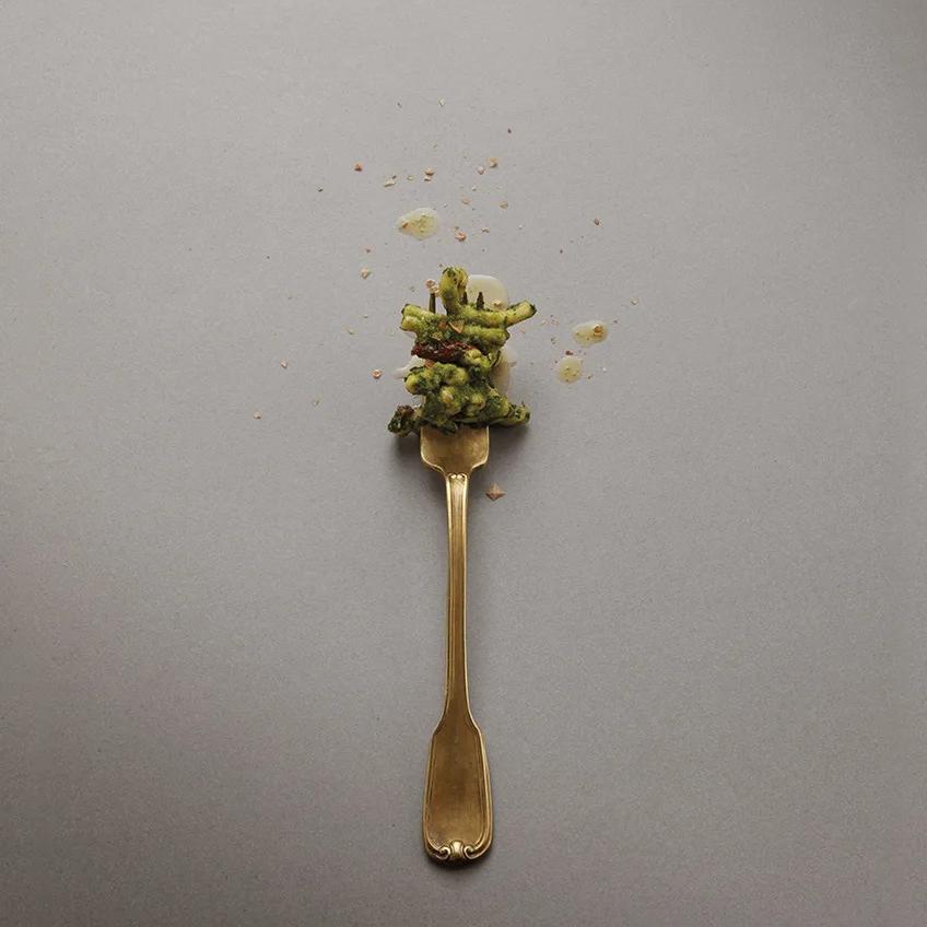 Wooden spoon with dried flowers resting on elegant Bercy porcelain slabs grey surface.