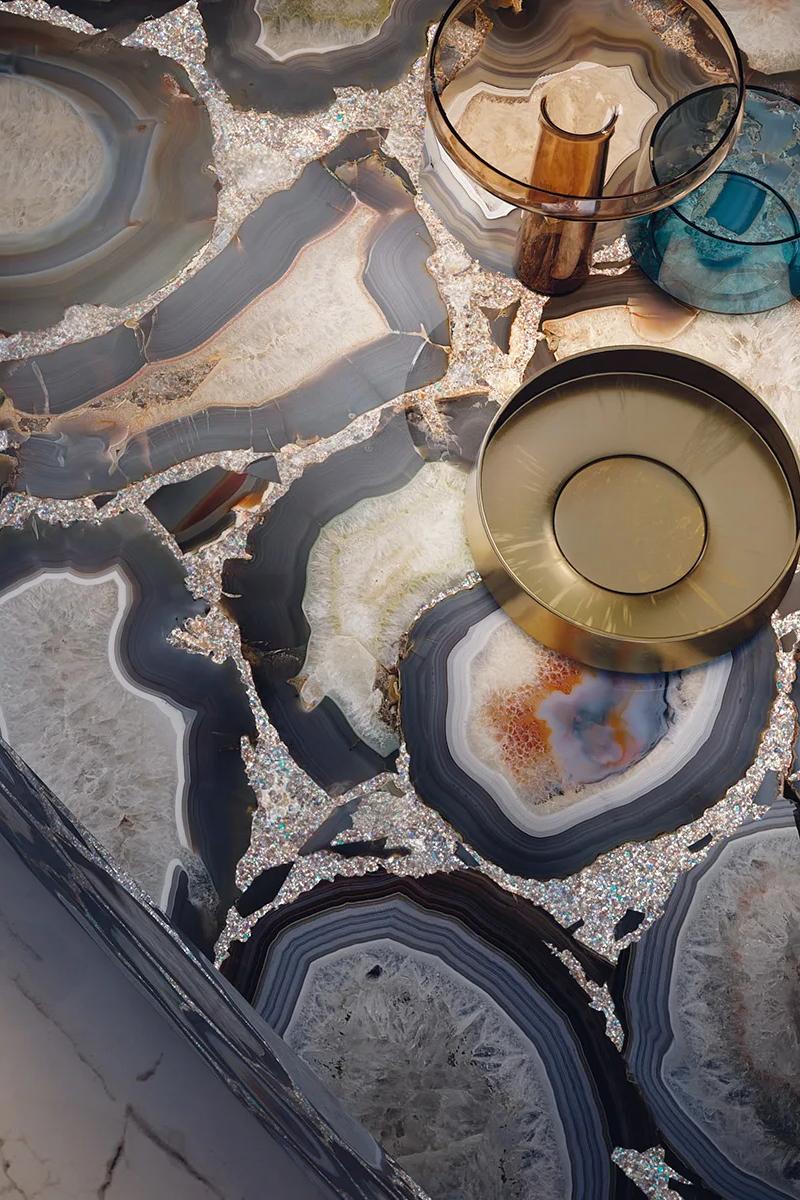 Top-down view of Cammeo porcelain slabs countertop alongside warm-toned glass decor pieces.