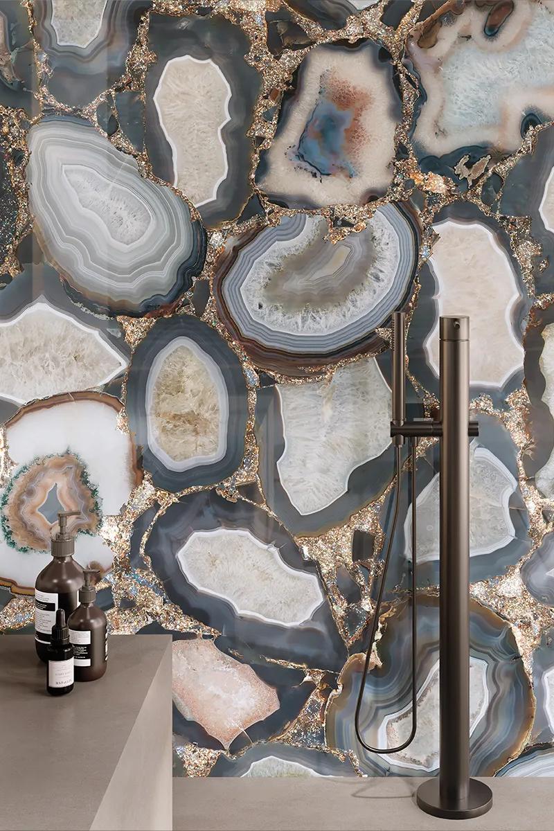 Floor-mounted faucet beside a wall covered in large-format Cammeo porcelain slabs.