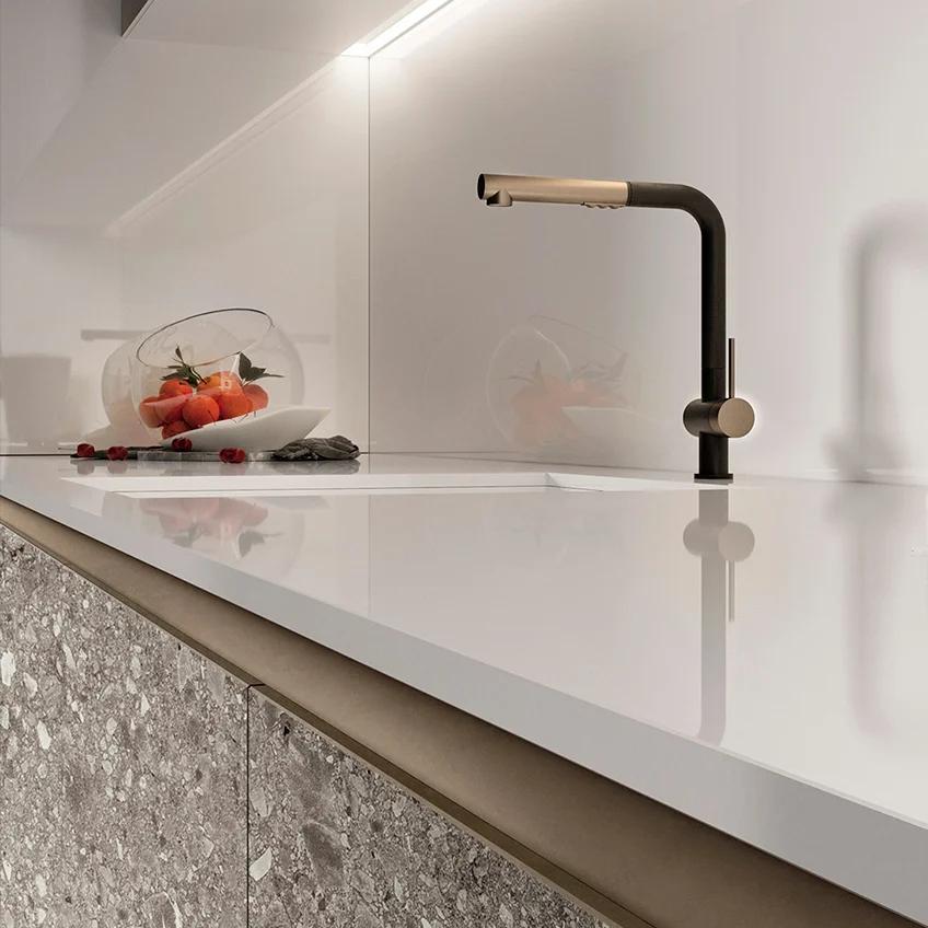 Black kitchen faucet on white counter with Milan Stone porcelain slabs wall cladding