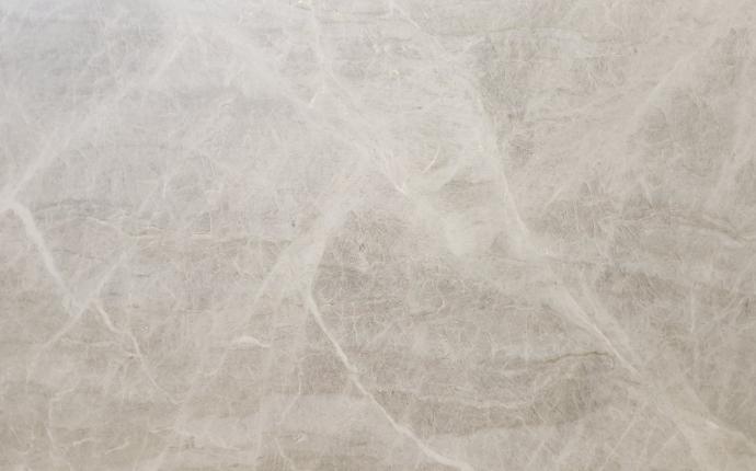 Honed Taj Mahal quartzite slab with pale gray-beige base and soft wispy veining at Nova Tile and Stone Minden
