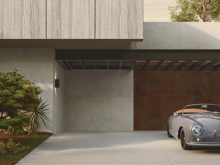 Modern home exterior featuring Travertino Trilogy porcelain slabs on facade with carport and vintage car.