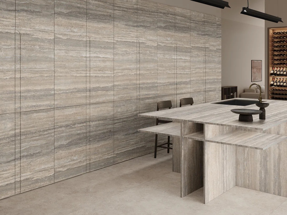 Kitchen space with Travertino Trilogy porcelain slabs on walls and matching island with bar stools.