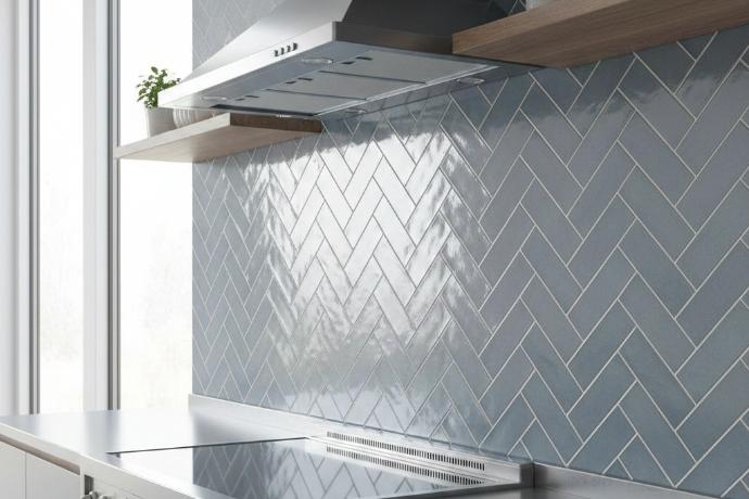 Glossy blue herringbone subway tile backsplash in kitchen